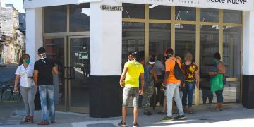 Personas observan a través de las vidrieras de la tienda Doble Nueve, en la calle San Rafael de La Habana, una de las nuevas tiendas que iniciaron la venta de artículos en Moneda Libremente (MLC) este lunes 20 de julio de 2020. Foto: Otmaro Rodríguez.