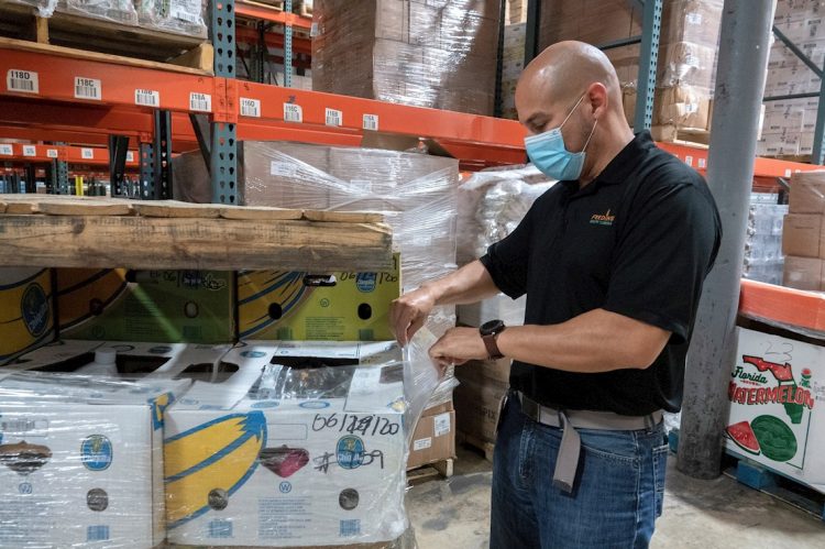 Paco Vélez, director de Feeding South Florida, revisa los productos en su almacén en Pembroke Park, el mayor banco de alimentos de Miami-Dade. Foto: Cristóbal Herrera / EFE.