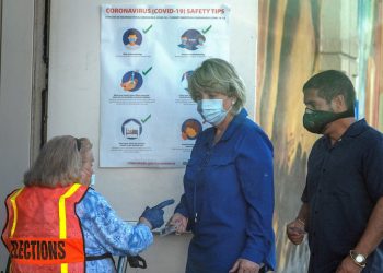 En día de elecciones primarias locales, dos electores se identifican en el centro de votación protegidos contra la pandemia. | Cristóbal Herrera / EFE