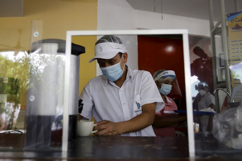 Trabajadores con mascarilla en un restaurante de El Salvador. Foto: Rodrigo Sura / EFE.
