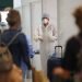 Personal médico espera para revisar a pasajeros en el aeropuerto Malpensa de Milán, el jueves 20 de agosto de 2020. (AP Foto/Antonio Calanni)