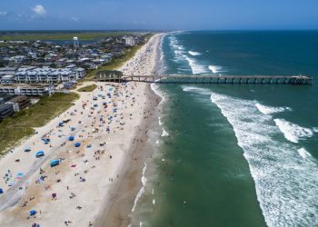 Bañistas en la playa de Wrightsville, Carolina del Norte, el domingo 2 de agosto de 2020, mientras la tormenta tropical Isaías avanza por la costa sureste del país. Foto: Travis Long/The News & Observer via AP.