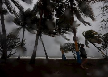 Una persona camina entre la lluvia y los fuertes vientos debido al paso de la tormenta Laura hoy, en Arroyo, sur de Puerto Rico. Foto: Thais Llorca/EFE.