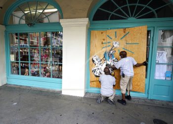 Trabajadores protegen tiendas en el barrio francés de Nueva Orleans. Foto: Gerald Herbert.