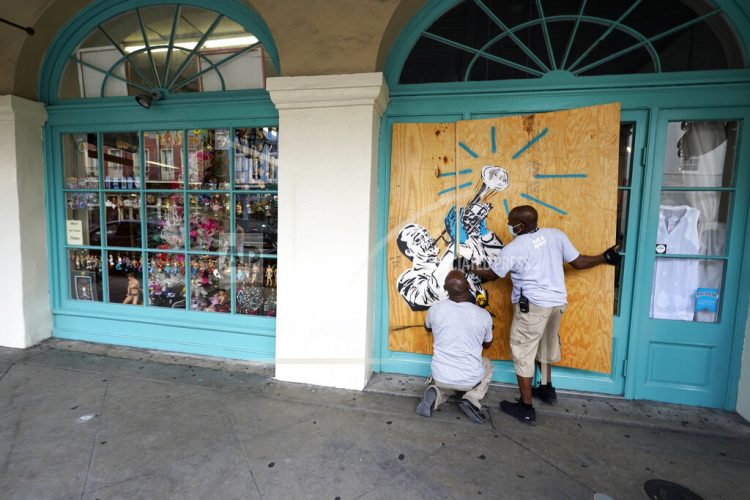 Trabajadores protegen tiendas en el barrio francés de Nueva Orleans. Foto: Gerald Herbert.
