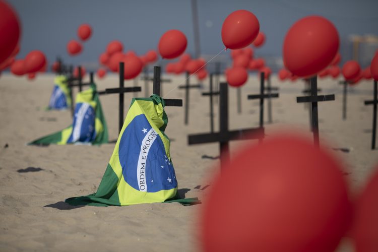 Cruces, globos rojos y la bandera de Brasil son colocados en la playa de Copacabana por el organismo no gubernamental Río de Paz en honor a las víctimas de COVID-19, en Río de Janeiro, Brasil, el sábado 8 de agosto de 2020.  Foto:Mario Lobao/AP.