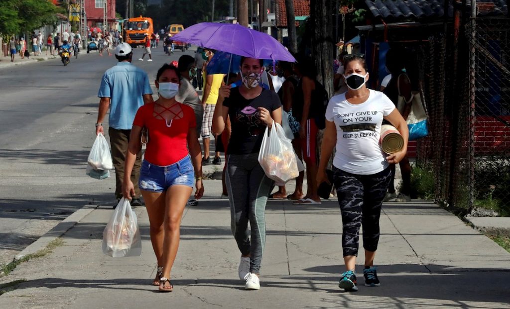 Personas con mascarillas en La Habana, durante la pandemia de la COVID-19. Foto: Ernesto Mastrascusa / EFE.