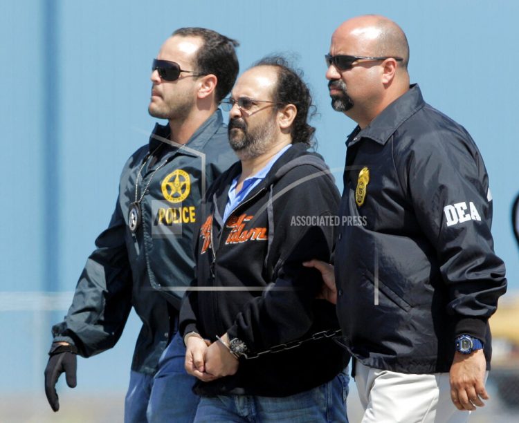 En esta imagen del 13 de mayo de 2008, el paramilitar colombiano Rodrigo Tovar es escoltado por agentes de la DEA en el aeropuerto de Opa-Locka, Florida. Foto: Alan Diaz/AP.