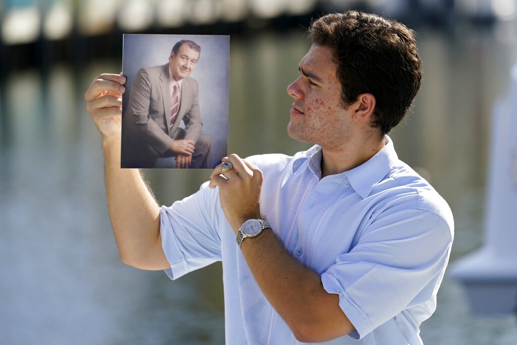 Freddy Vallejo Jr. muestra una foto de su abuelo Jorge Vallejo, el patriarca de la familia, un médico cubano que emigró e hizo su vida en la Florida. El abuelo y uno de sus hijos, Carlos, ambos médicos, fallecieron por el coronavirus. Foto: Lynne Sladky / AP.