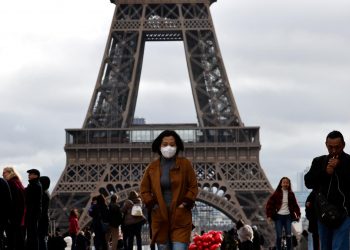 En esta imagen de archivo, una mujer usa una máscara protectora mientras camina en la explanada del Trocadero frente a la Torre Eiffel en París, en marzo de 2020. Foto: Gonzalo Fuentes/Reuters.