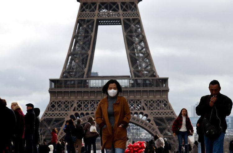 En esta imagen de archivo, una mujer usa una máscara protectora mientras camina en la explanada del Trocadero frente a la Torre Eiffel en París, en marzo de 2020. Foto: Gonzalo Fuentes/Reuters.