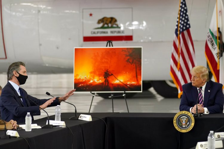 El presidente Trump escucha al gobernador Gavin Newsom informarle sobre los incendios que afectan a California, el lunes 14 de septiembre de 2020 en el aeropuerto McClellan de Sacramento, California. Foto: Andrew Harnik/AP.