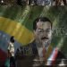 Un individuo con mascarilla pasa frente a un mural del presidente Nicolás Maduro en Caracas el 22 de julio de 2020. Foto: Ariana Cubillos/AP.