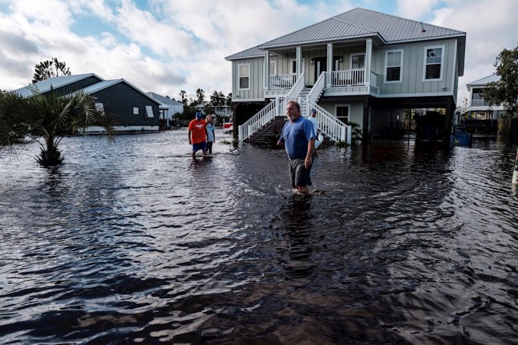 Una familia intenta cruzar una calle en Orange Beach, Alabama, inundada por el huracán Sally. Foto: Dan Anderson / EFE.