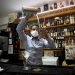 Con máscaras para protegerse del nuevo coronavirus, el bartender Dagoberto Jesús Morejón prepara un cóctel con plantas endémicas de Cuba, mientras su socio Manuel Alejandro Valdés lo respalda en La Habana, Cuba, el martes 13 de octubre de 2020. Foto: AP/Ismael Francisco.