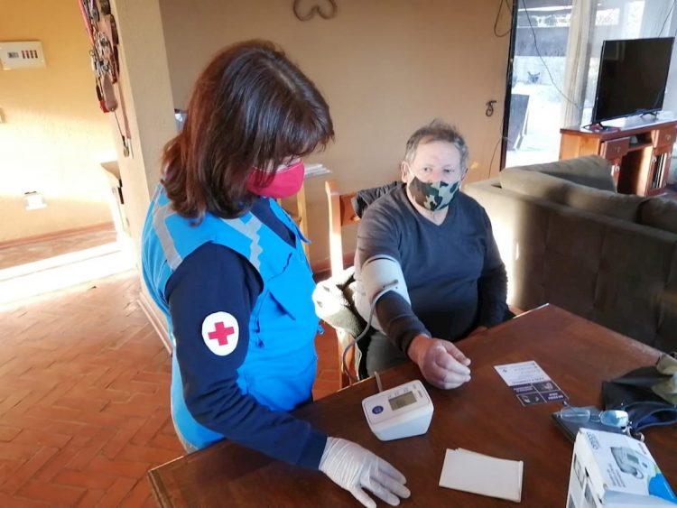 Fotografía cedida por la Cruz Roja Internacional que muestra a una funcionaria del ente mientras participa en labores de apoyo a adultos mayores en medio de la pandemia, en Chile. Foto: EFE/ Cruz Roja Internacional.