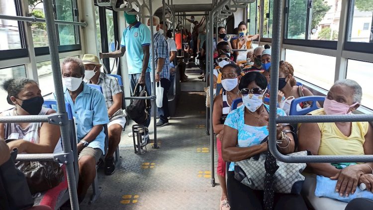 Decenas de personas usan este lunes tapabocas mientras van en un bus de transporte urbano, en La Habana (Cuba). Foto: EFE/Ernesto Mastrascusa.
