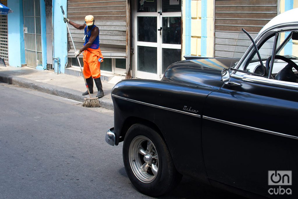 Un trabajador de servicios comunales limpia la calle Neptuno, durante la desescalada post COVID-19 en La Habana. Foto: Otmaro Rodríguez.