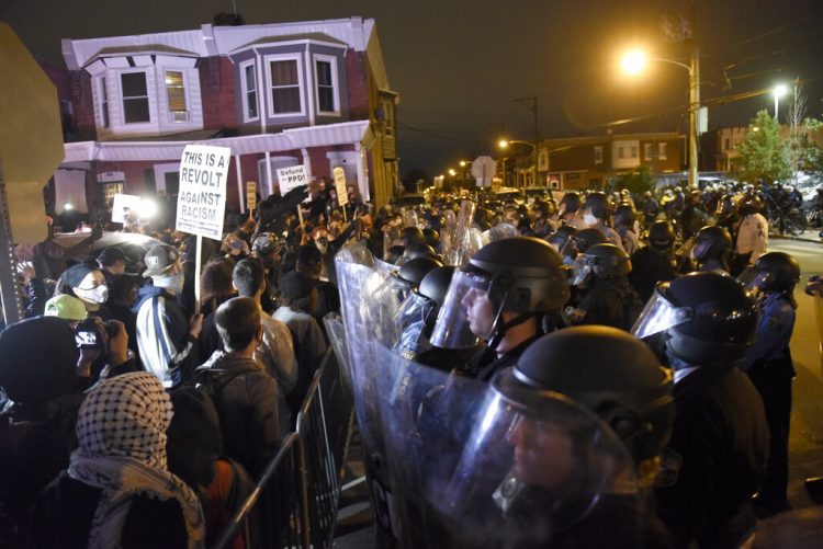 La policía vigila a manifestantes en Filadelfia el 27 de octubre del 2020, luego de que la muerte de un individuo de raza negra a manos de la policía generase protestas. Foto: Michael Pérez/AP.