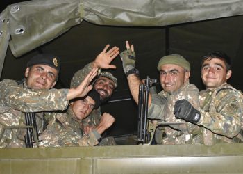En esta imagen difundida el martes 6 de octubre de 2020, soldados armenios saludan a un fotógrafo mientras viajan en la parte trasera de un camión durante el combate con fuerzas de Azerbaiyán en la autoproclamada República de Nagorno Karabaj, el domingo 4 de octubre de 2020. Foto: Oficina de prensa del Ministerio de Defensa de Armenia, vía AP.