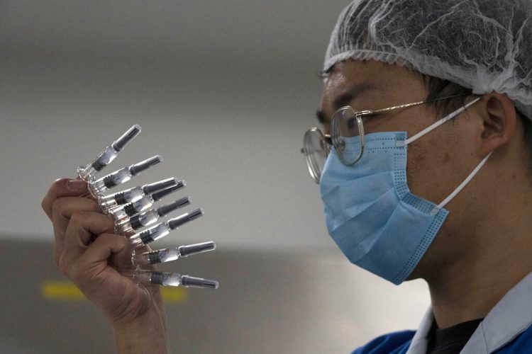 Un empleado inspecciona jeringas para la vacuna contra el COVID-19 producida por Sinovac en su fábrica de Beijing. Foto: Ng Han Guan/AP/Archivo.