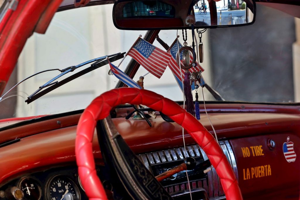 Vista del interior de un automóvil clásico de fabricación norteamericana, adornado con banderas de Cuba y Estados Unidos en La Habana. Foto: Ernesto Mastrascusa / EFE/Archivo.