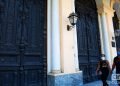 Unas personas pasan frente a unas puertas exteriores en La Habana. Foto: Otmaro Rodríguez.