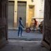 Unas personas pasan frente a unas puertas exteriores en La Habana. Foto: Otmaro Rodríguez.