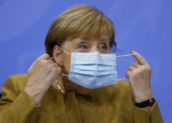 La canciller alemana Angela Merkel se retira la mascarilla el miércoles 25 de noviembre de 2020 antes de una conferencia de prensa. Foto: Odd Andersen/Pool Foto vía AP.