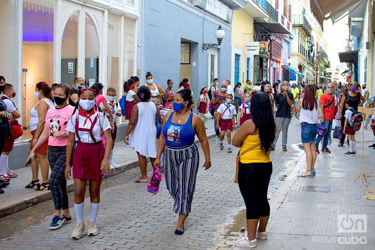 Personas con mascarillas en la calle Obispo de La Habana, entre ellas estudiantes de la enseñanza primaria, tras el reinicio del curso escolar en la capital cubana. Foto: Otmaro Rodríguez.