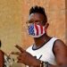 Un joven usa una mascarilla con diseño de la bandera de Estados Unidos, mientras posa para una foto en La Habana. Foto: Ernesto Mastrascusa / EFE.