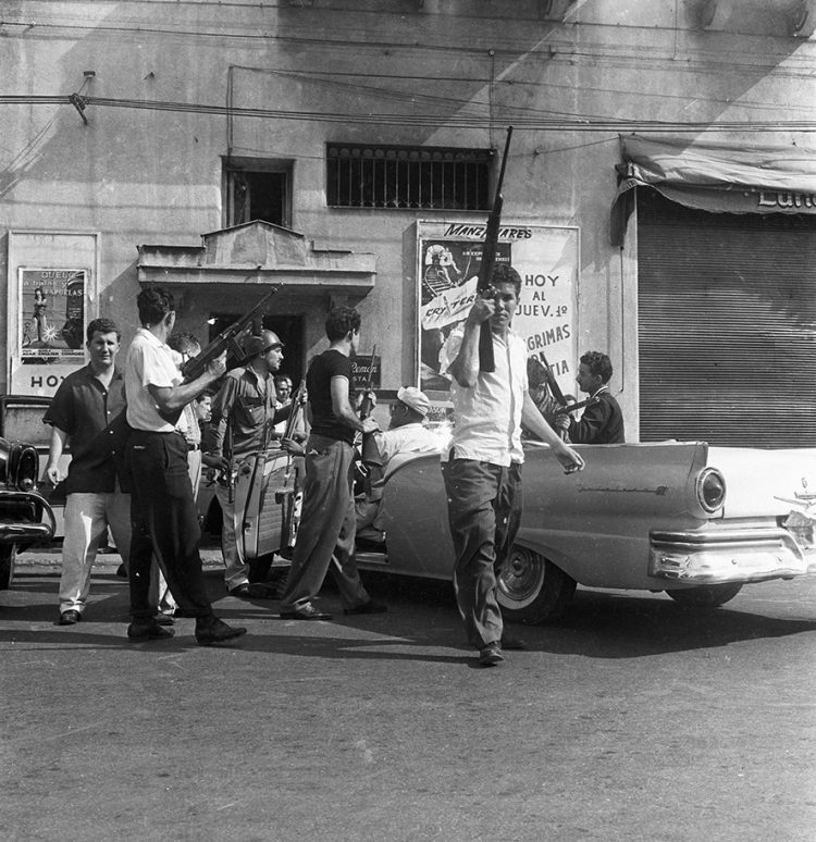 Grupo de personas disparando-desde-el-costado-del-cine-Mazanares al-edificio-de-Carlos-III-e-infanta, el 1ero de enero de 1959. Foto: Ernesto Fernández.