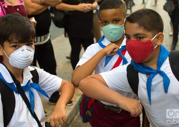 Tres niños se saludan antes de entrar a su escuela en La Habana, durante la pandemia de la COVID-19. Foto: Otmaro Rodríguez / Archivo.