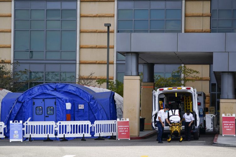 Trabajadores médicos retirando una camilla de una ambulancia cerca de carpas médicas erigidas afuera de la sala de emergencias del UCI Medical Center en Irvine, California.  Foto: Ashley Landis/ Archivo/AP.