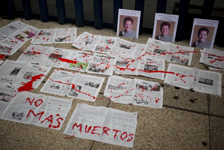 "No más muertos", el mensaje escrito sobre periódicos en frente de las fotografías de la periodista mexicana Miroslava Breach, asesinada en 2017. Foto: Eduardo Verdugo/AP/ Archivo.