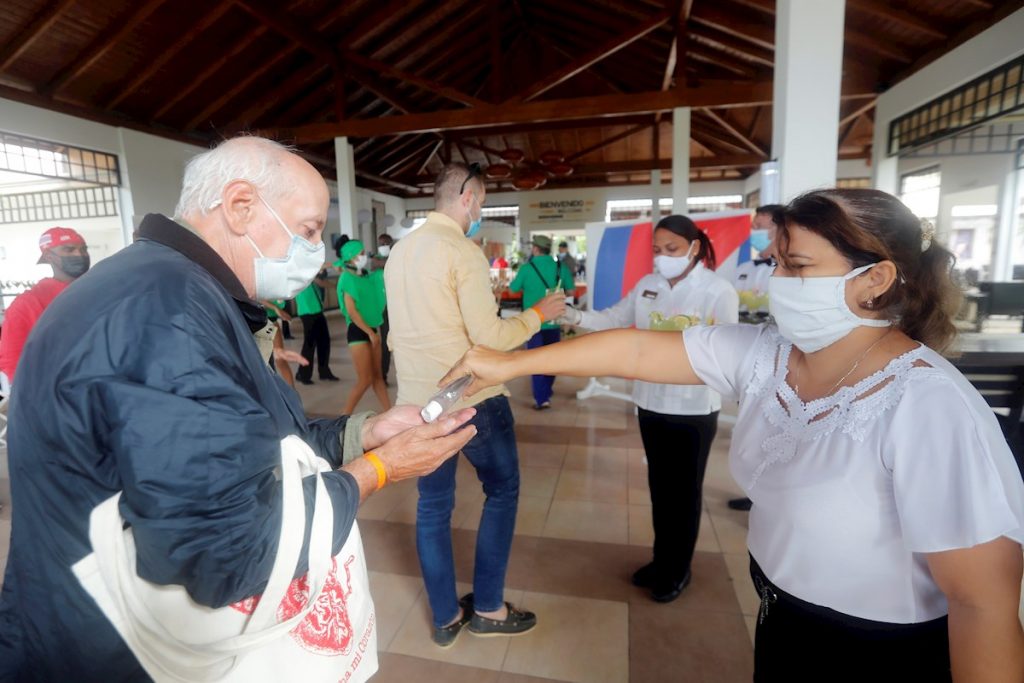 Trabajadoras del turismo ofrecen gel desinfectante a los visitantes que llegan a un hotel en Cayo Coco, Cuba, en diciembre de 2020. Foto: Ernesto Mastrascusa / EFE / Archivo.