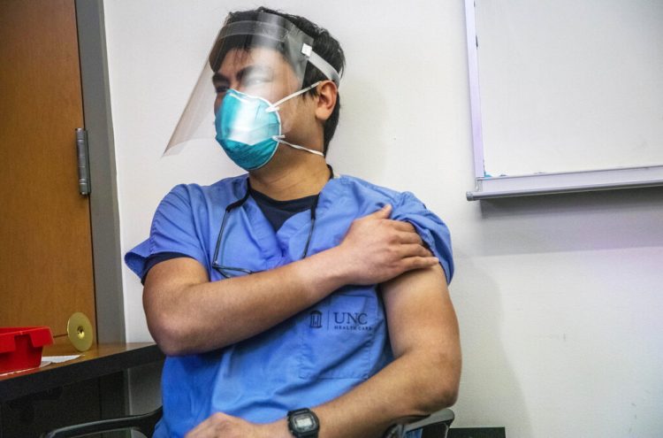 El doctor Aidin Ashoori se aprieta el hombro tras recibir una dosis de la vacuna contra la COVID-19 el jueves 17 de diciembre en el hospital UNC Health, en Chapel Hill, Carolina del Norte. Foto Travis Long/The News & Observer vía AP.