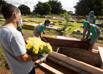Empleados preparan a víctimas mortales de la COVID-19 para ser enterradas en el cementerio de Campo da Esperança, en Brasilia (Brasil). Foto: Joédson Alves / EFE / Archivo.