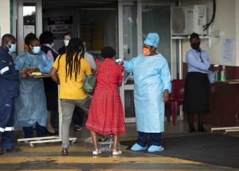 Una trabajadora de salud revisa la temperatura de una paciente en la entrada de la sala de emergencias del Hospital Académico Steve Biko, en Pretoria, Sudáfrica, el lunes 11 de enero de 2021. Foto: AP/Themba Hadebe.