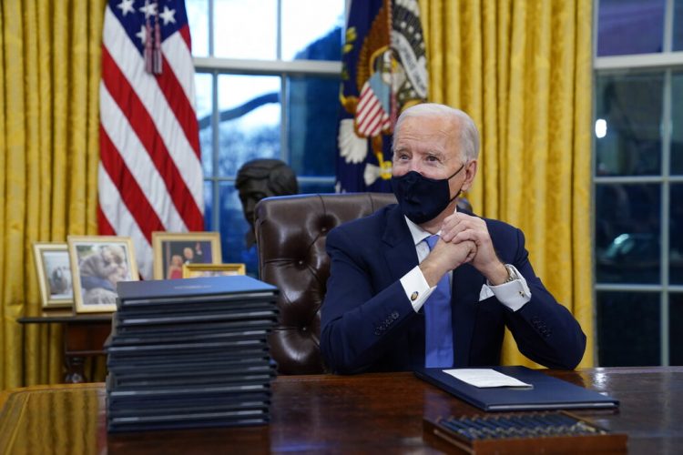 Fotografía de archivo del 20 de enero de 2021 del presidente Joe Biden esperando firmar su primera orden ejecutiva en la oficina Oval de la Casa Blanca en Washington. (AP Foto/Evan Vucci, Archivo)