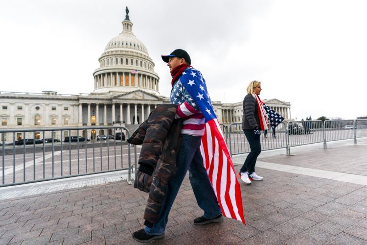 Un simpatizante del presidente Trump camina frente al Capitolio el martes 5 de enero de 2021. Foto:  Manuel Balce Ceneta/AP.