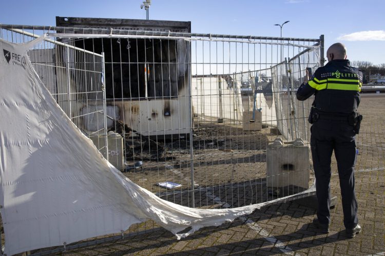 Un policía enbel pueblo pesquero holandés de Urk, el domingo 24 de enero de 2021. El puesto fue incendiado durante unos disturbios durante la primera noche de un toque de queda nacional. Foto: Peter Dejong/AP.
