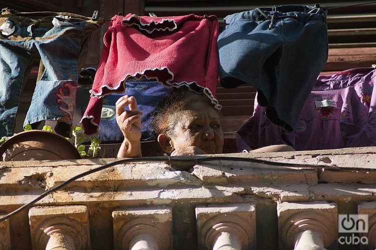 Una anciana se asoma al balcón durante el rebrote de la COVID-19 en La Habana, en enero de 2021. Foto: Otmaro Rodríguez.