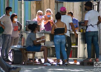 Unos turistas y otras personas en un puesto de venta de churros durante el rebrote de la COVID-19 en La Habana, en enero de 2021. Foto: Otmaro Rodríguez.