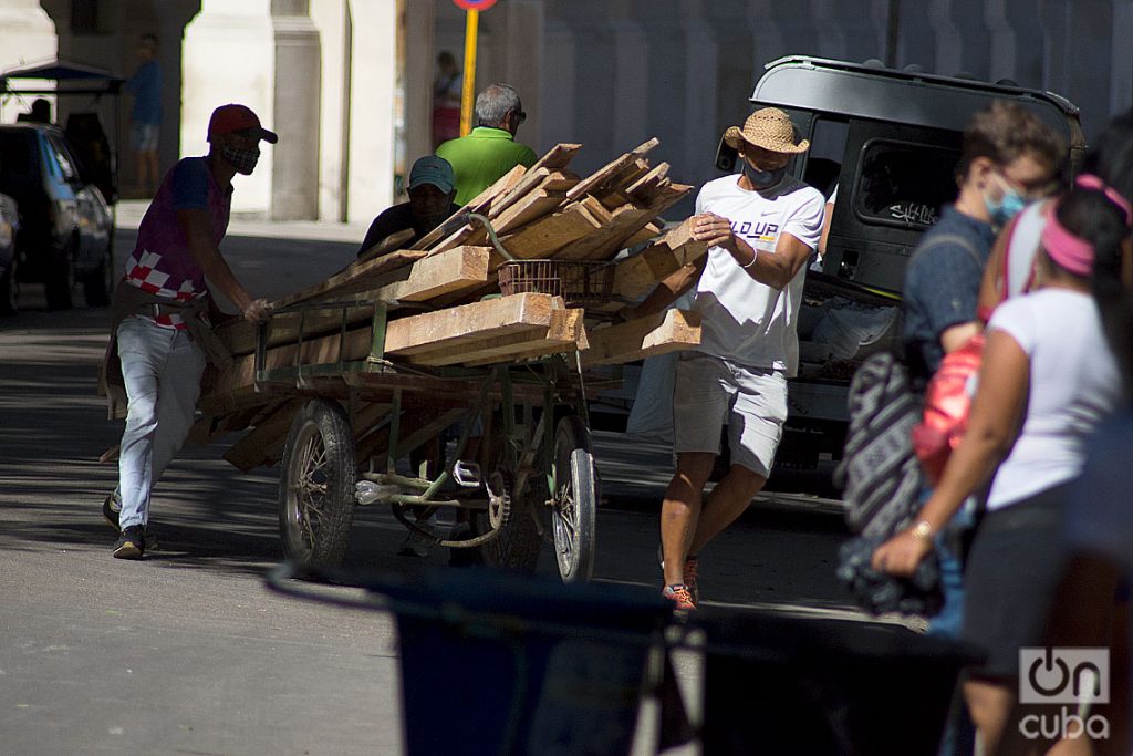 Hombres transportando madera durante el rebrote de la COVID-19 en La Habana, en enero de 2021. Foto: Otmaro Rodríguez.