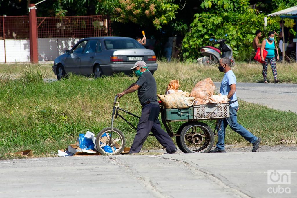 Personas transportan mercancías durante el rebrote de la COVID-19 en La Habana, en enero de 2021. Foto: Otmaro Rodríguez.