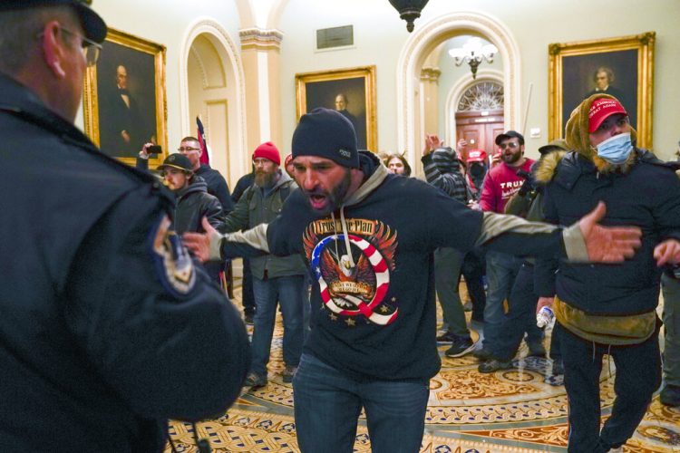 Simpatizantes del presidente saliente Donald Trump se enfrentan a la policía del Capitolio en el vestíbulo del recinto del Senado, el miércoles 6 de enero de 2021, en Washington. Foto: Manuel Balce Ceneta/AP.