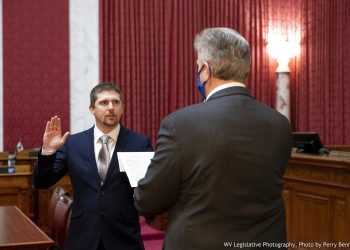 El legislador de Virginia Occidental Derrick Evans, izquierda, juramenta en la Cámara de Delegados el 14 de diciembre del 2020, en Charleston. El delegado estatal está acusado de ingresar a un área restringida del Capitolio estadounidense luego que transmitió en vivo un video en el que se le ve irrumpiendo en el edificio con una turba de partidarios del presidente Donald Trump. Foto: Perry Bennett/Legislatura de Virginia Occidental vía AP.