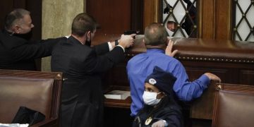 Policías apuntan con sus armas a un manifestante que intenta entrar en la Cámara de Representantes del Capitolio de los EE.UU. Foto: J. Scott Applewhite/AP