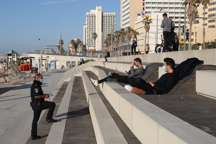 Policías interroga a personas en la playa durante un cierre nacional en Tel Aviv. Foto: ABIR SULTAN/EFE/EPA/